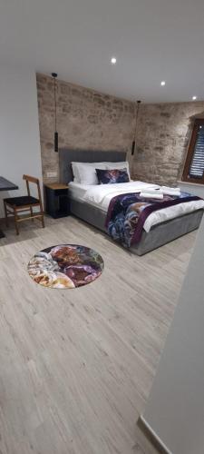 1 dormitorio con 1 cama grande y pared de ladrillo en Wila properties doo Studio Christopher en Split