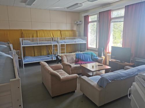 Cette chambre comprend 2 lits superposés, un canapé et une table. dans l'établissement Ryhmämajoitus, à Lappeenranta