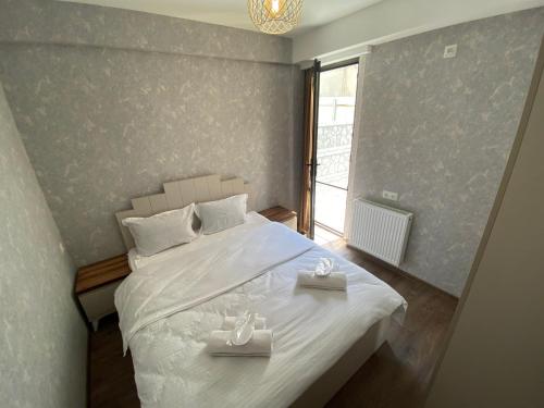 - une chambre avec un lit blanc et 2 plateaux dans l'établissement Apartment Nizami Kutaisi, à Koutaïssi