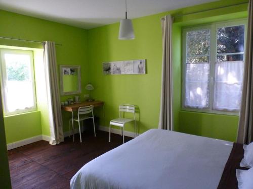 - une chambre avec des murs verts, un lit et un bureau dans l'établissement LePireau fr Gîte Maître Futuroscope Piscine chauffée, à Vouneuil-sur-Vienne