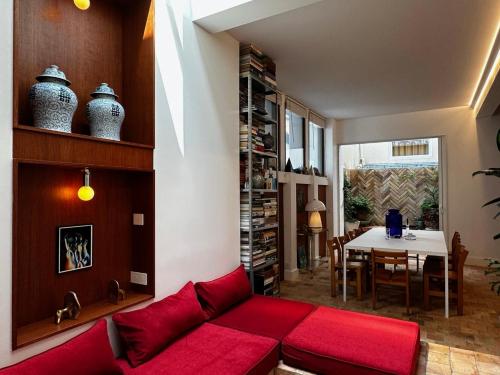 - un salon avec un canapé rouge et une table dans l'établissement Maison MAÏTÉ, au cœur de Biarritz, à Biarritz