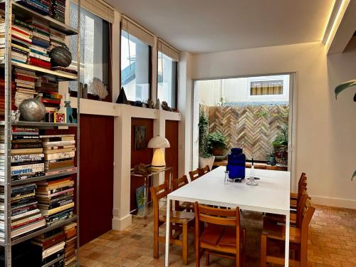 une salle à manger avec une table et des chaises blanches dans l'établissement Maison MAÏTÉ, au cœur de Biarritz, à Biarritz