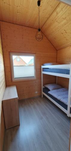 a room with two bunk beds and a window at Domki Dafi in Jarosławiec