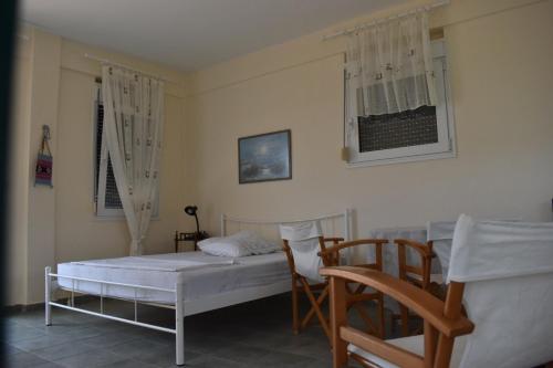 a bedroom with two beds and two chairs at Earthly paradise Kariani in Karianí