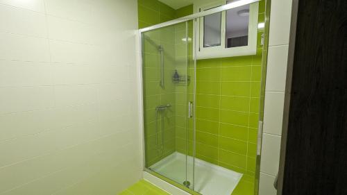 a bathroom with a shower with green tiles at Playa de Liméns in Cangas de Morrazo