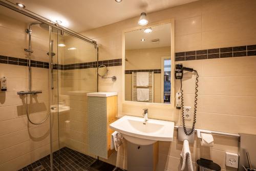 a bathroom with a sink and a shower at City-Appartements Am Wall in Goslar