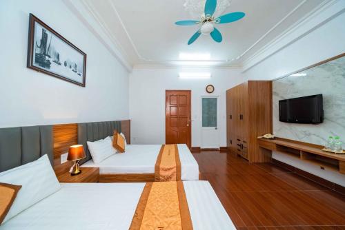 Habitación de hotel con 2 camas y TV de pantalla plana. en Sun & Sea Hotel, en Hai Phong