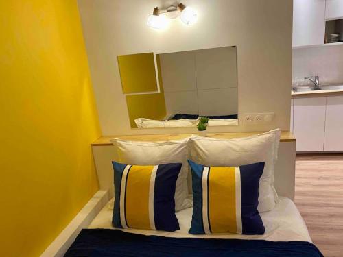 1 dormitorio con 1 cama con 2 almohadas y espejo en Studio Marseille centre-ville, en Marsella