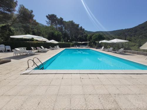 une grande piscine avec des chaises et des parasols dans l'établissement Isca della Contessa, à Palinuro