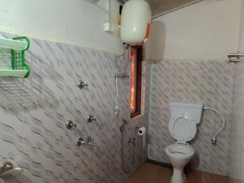 a bathroom with a toilet and a red light at The Himalayan Resort in Ravangla