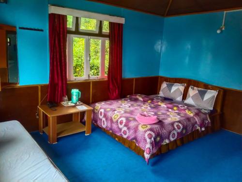 a bedroom with a bed and a table and a window at The Himalayan Resort in Ravangla