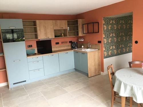 une cuisine avec des placards blancs et une table avec un chiffon de table dans l'établissement Gîte de charme en Drôme Provençale - La Saulée, à Souspierre