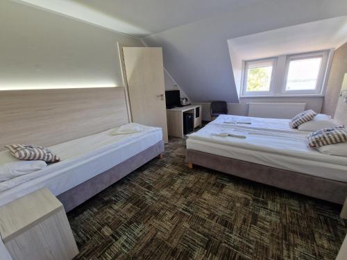 a bedroom with two beds and a window at Willa Nest in Unieście