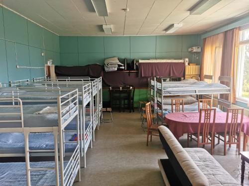 a room with several bunk beds and tables and chairs at Ryhmämajoitus in Lappeenranta