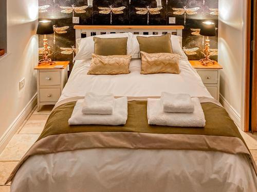 1 dormitorio con 1 cama grande con 2 almohadas en Dovecote, en Stoke Bruerne