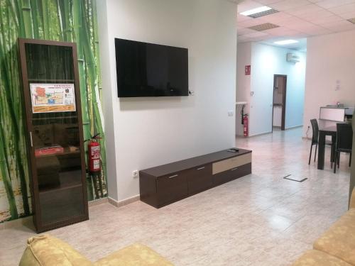 a living room with a flat screen tv on a wall at Albergue El Templarin in Ponferrada