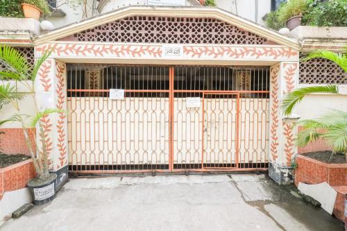 einen Eingang zu einem Haus mit einem orangenen Tor in der Unterkunft Ur Homestay Luxury in Dhaka
