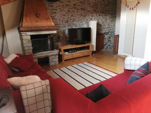 - un salon avec un canapé rouge et une cheminée dans l'établissement Affascinante appartamento ai piedi dell'ovovia, à Courmayeur