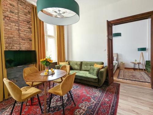 salon z kanapą, stołem i krzesłami w obiekcie Apartamenty Strzelecka 34 w Poznaniu