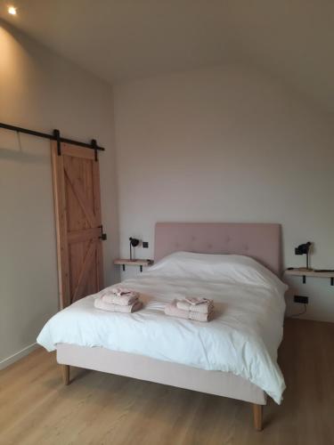 een slaapkamer met een bed met twee handdoeken erop bij Komo Hill Stays - guestroom Komo Cosy in Kruisem