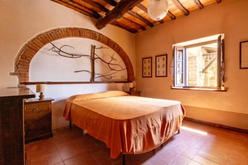 Schlafzimmer mit einem Bett und einem Fenster in der Unterkunft Castello di Selvole in Vagliagli