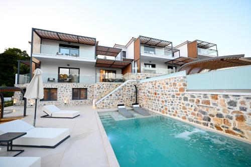a house with a swimming pool next to a building at ROYAL VIEW VILLAS in Skiathos