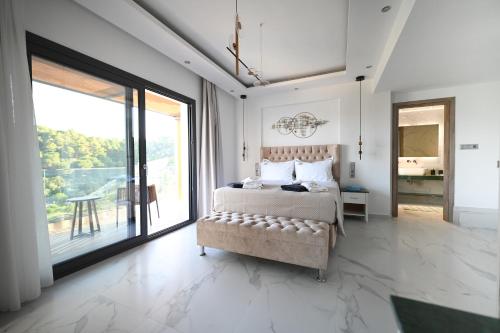 a bedroom with a bed and a large window at ROYAL VIEW VILLAS in Skiathos Town