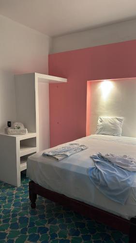 - une chambre dotée d'un lit avec un mur rouge dans l'établissement Hotel Casa Cactus HCC, à Chachalacas