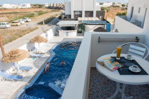 a balcony with a pool and a table and chairs at Villa Valvis in Perissa