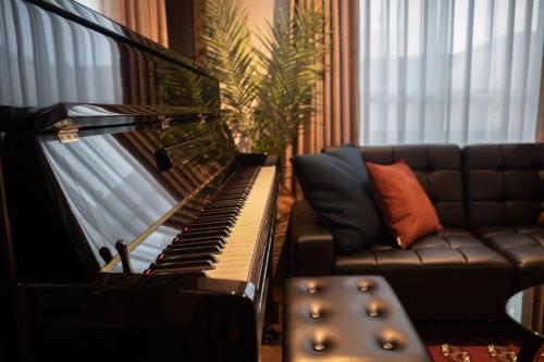 a piano and a couch in a living room at Acoustic GARAGE by Tranova in Tokyo