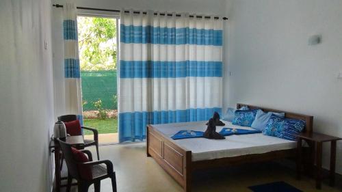 sypialnia z łóżkiem i dużym oknem w obiekcie Villa Nemo w mieście Wayikkal