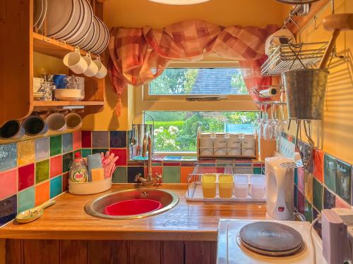 uma cozinha com um lavatório e uma janela em Yelt Cottage em Wootton