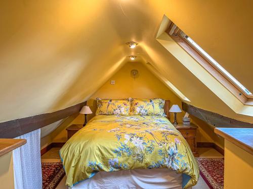 um quarto com uma cama no sótão em Yelt Cottage em Wootton