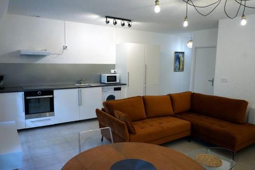 Il comprend un salon avec un canapé et une cuisine. dans l'établissement Appartement n°31 Uzès centre, à Uzès