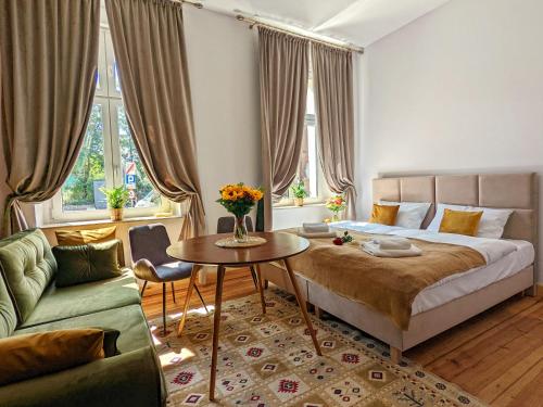 1 dormitorio con cama, mesa y sofá en Apartamenty Strzelecka 34, en Poznan