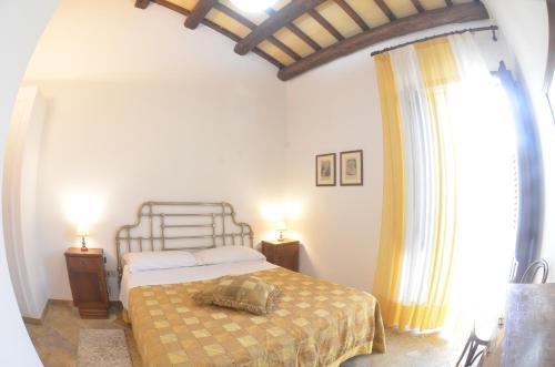 a bedroom with a bed and two lamps and a window at GIARDINO del MARE in Petrosino