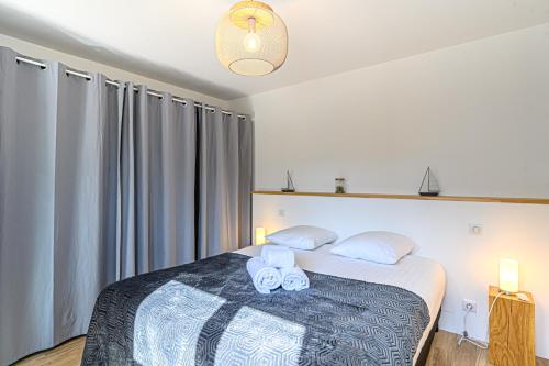 a bedroom with a bed with two towels on it at Maison au pied des sentiers côtiers in Vannes