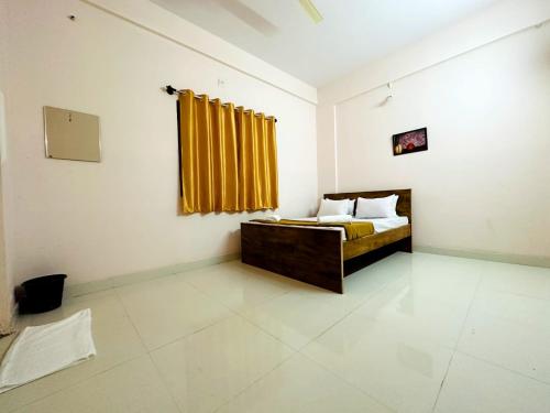 a bedroom with a bed with a yellow curtain at Vbh Inn- Affordable and Budget Friendly in Jigani