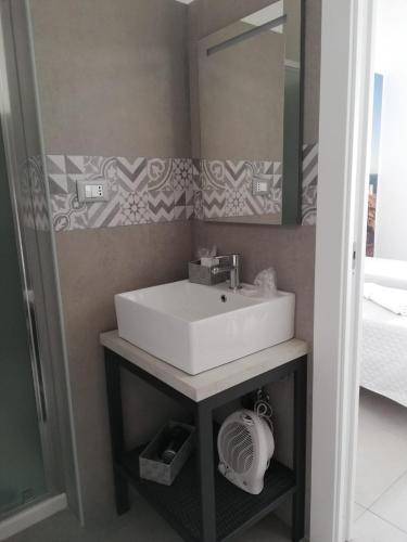 a bathroom with a sink and a mirror at KipoRooms in Zollino
