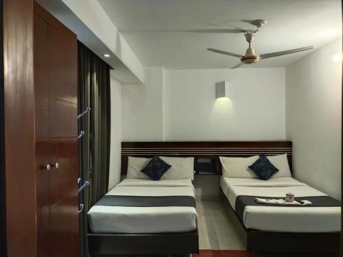 a bedroom with two beds and a ceiling fan at Shahjadi Resort in Cox's Bazar