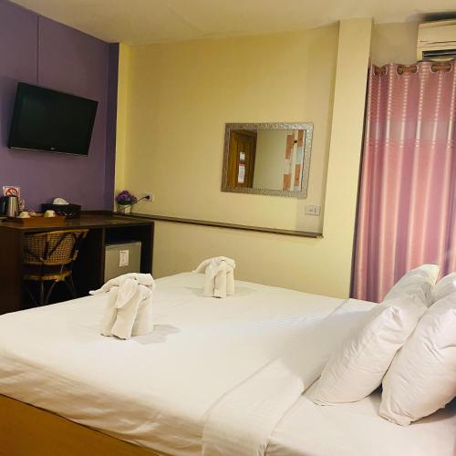 a hotel room with a bed with towels on it at Vieng Mantra Hotel in Chiang Mai