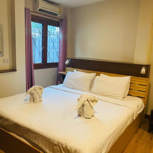 two stuffed animals are sitting on a bed at Vieng Mantra Hotel in Chiang Mai