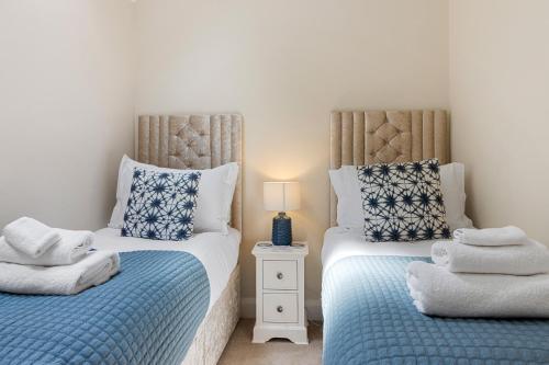 dos camas sentadas una al lado de la otra en un dormitorio en 1 Chapel Mews en Sidmouth