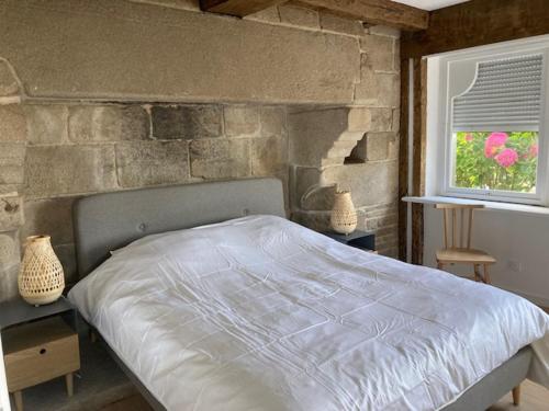 - une chambre avec un lit et un mur en pierre dans l'établissement Villa Ster et Mer, à Plobannalec-Lesconil
