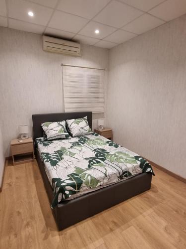 a bedroom with a bed with a green and white comforter at Appartement Centre ville in Chalon-sur-Saône