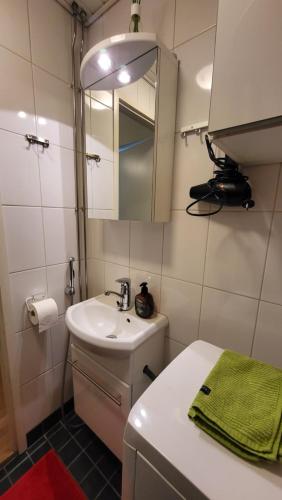 Baño pequeño con lavabo y espejo en Peaceful and beautiful apartment in Hämeenlinna, en Hämeenlinna
