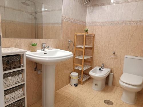 a bathroom with a sink and a toilet at Casa FLOYD in Caleta De Fuste