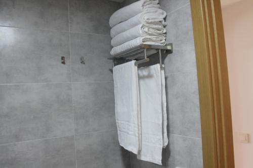 a bathroom with a shower with towels on a wall at Apartamento nuevo en urbanización a 250 metros de la playa in Denia