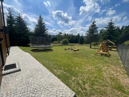 a yard with a playground with two play equipment at Polana Modraszek in Lasowka