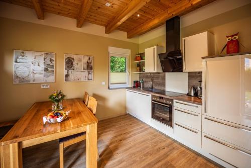 a kitchen with white cabinets and a wooden table at City-Appartements Am Wall in Goslar